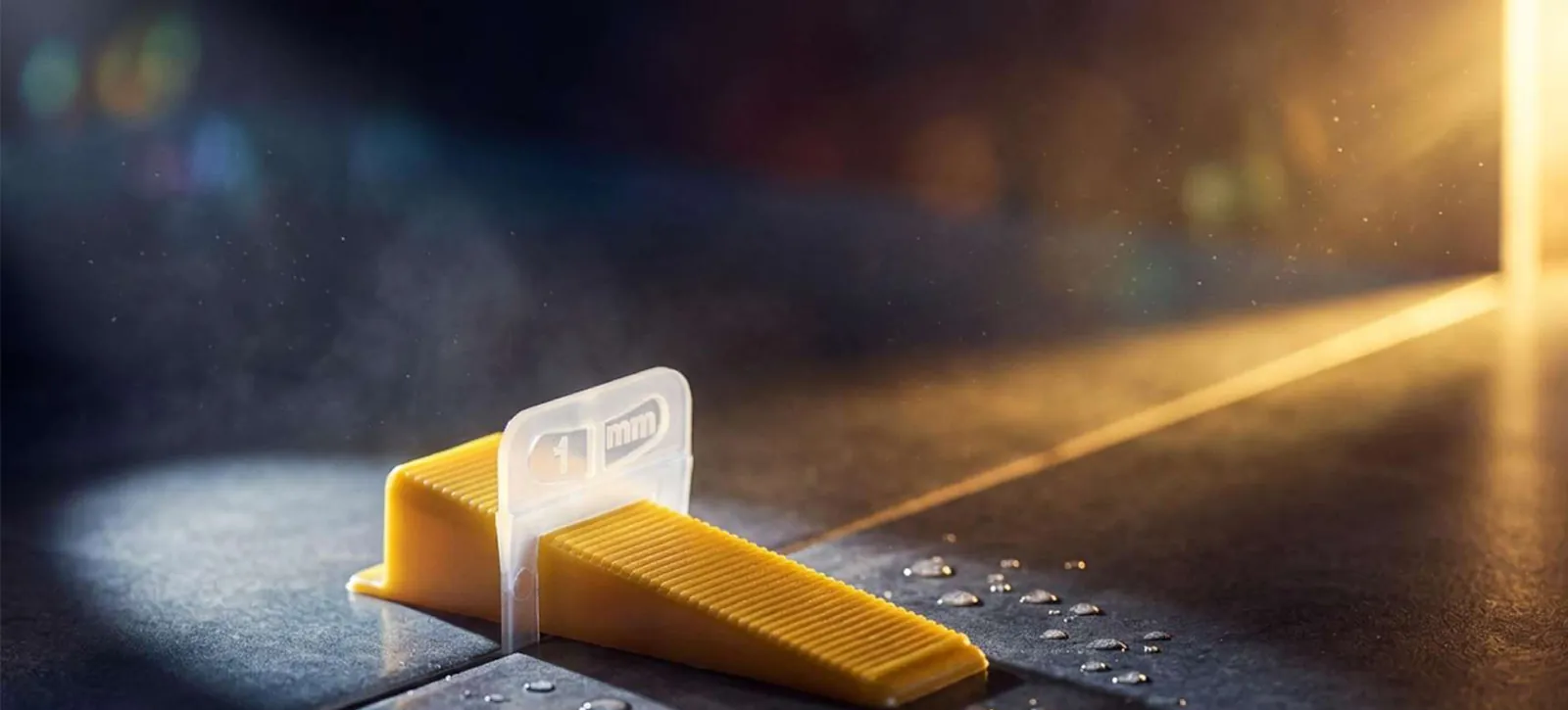 Levelingclip ILM-CL-1.0 voor 1 mm voegbreedte met gele kegg tussen twee tegels