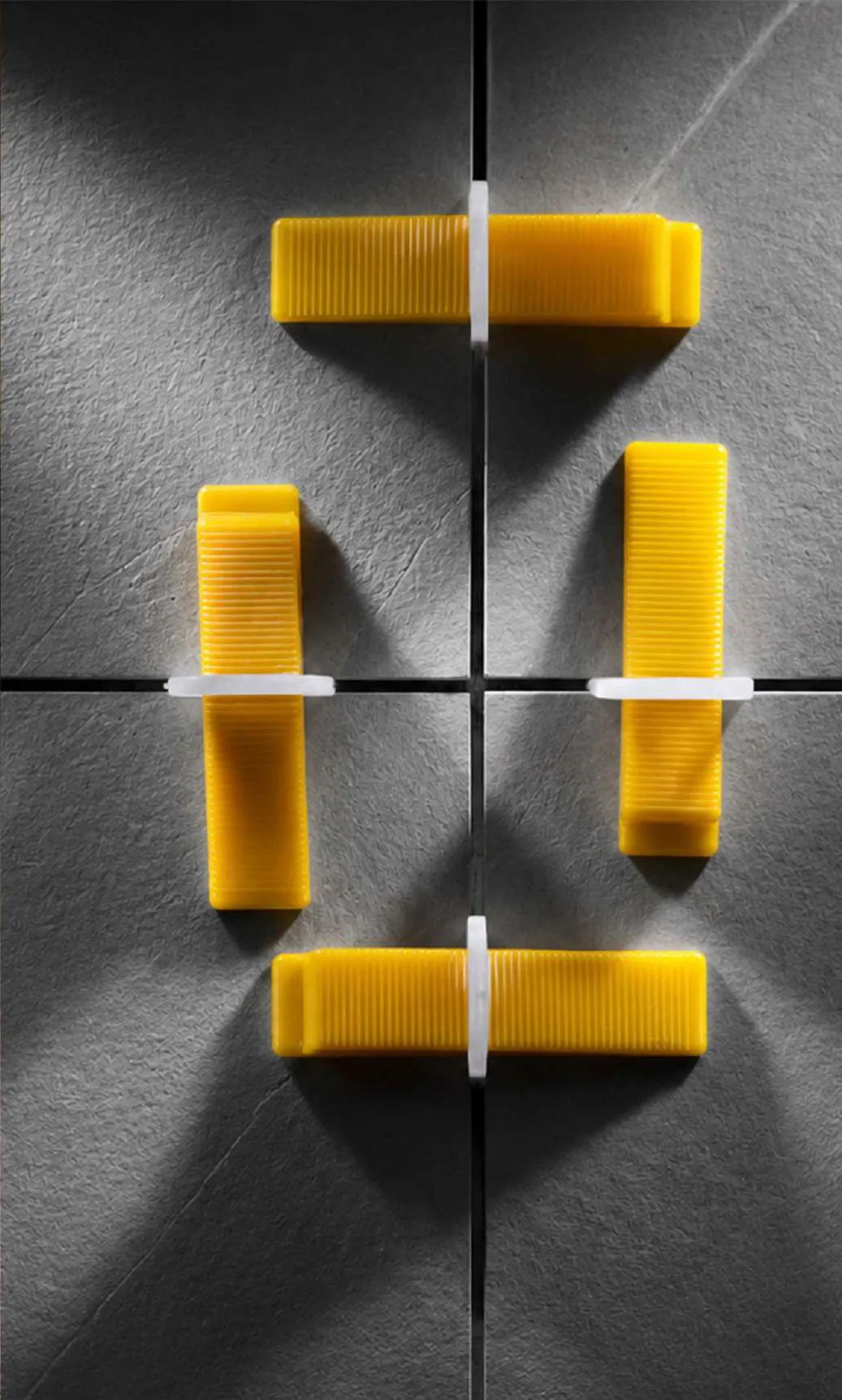Bovenaanzicht van keggen in levelingclips rond een tegelkruispunt